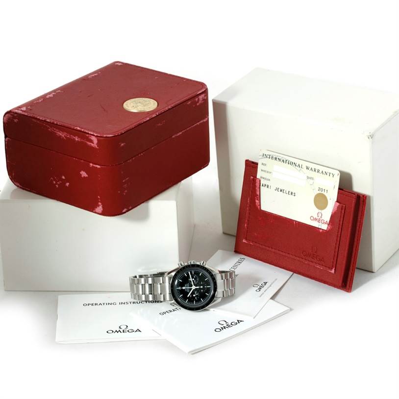 The image features an Omega Speedmaster 3570.50.00 Men
s Stainless Steel Black Dial 3570.50.00 Men
s Stainless Steel Black Dial watch with its original red box, warranty card, and instruction manuals.