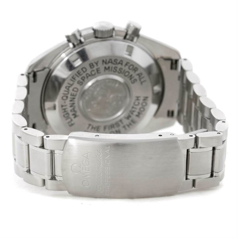 The image shows the back view of an Omega Speedmaster 3570.50.00 Men
s Stainless Steel Black Dial 3570.50.00 Men
s Stainless Steel Black Dial watch, highlighting its engraved case back and metal bracelet clasp.