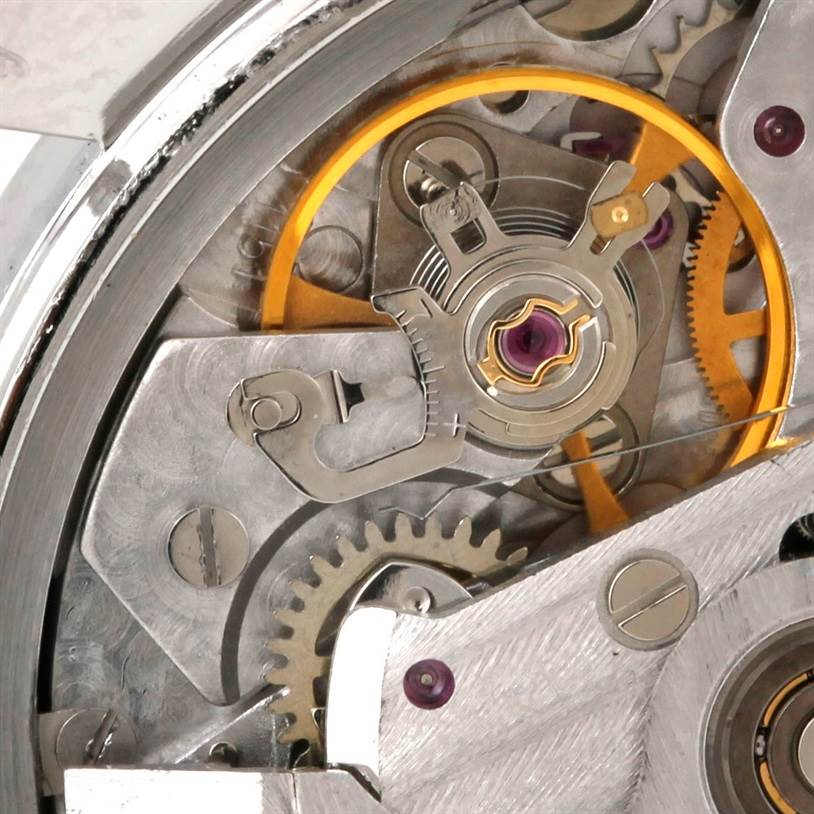 This close-up image of an Omega Speedmaster 3523.30.00 Men
s Stainless Steel Silver Dial 3523.30.00 Men
s Stainless Steel Silver Dial watch showcases the intricate internal mechanism and gears.