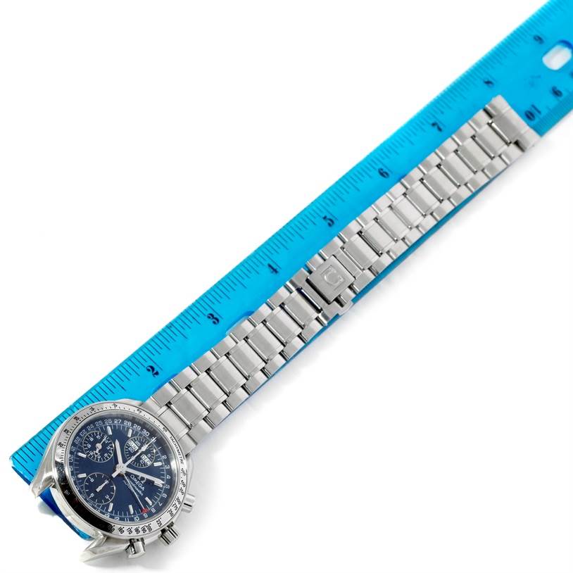 The image shows an Omega Speedmaster 3523.80.00 Men
s Stainless Steel Blue Dial 3523.80.00 Men
s Stainless Steel Blue Dial watch from a top-down view, placed next to a blue ruler for measuring.
