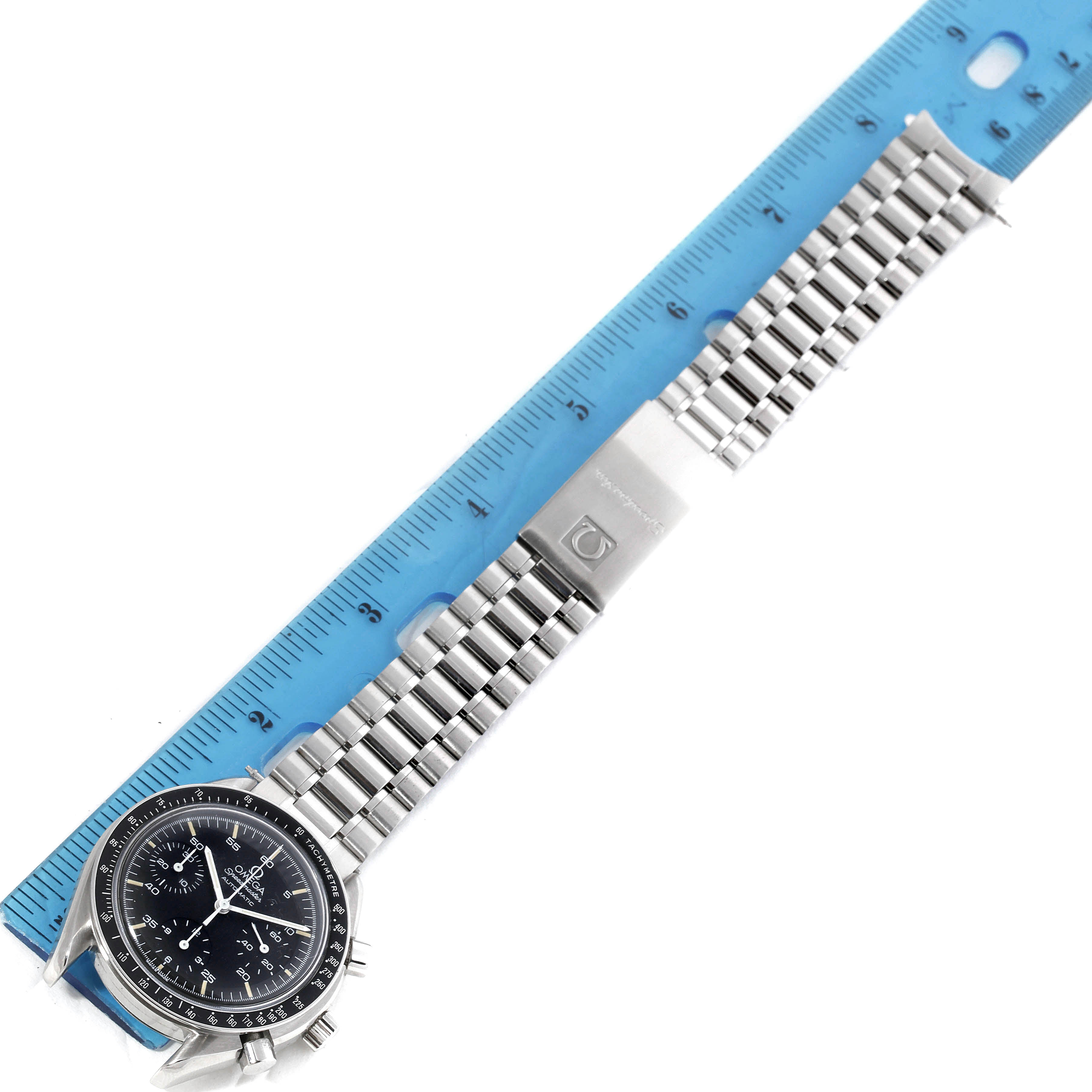The image shows an Omega Speedmaster 3510.50.00 Men
s Stainless Steel Black Dial 3510.50.00 Men
s Stainless Steel Black Dial watch lying flat with a ruler measuring the length of its metal bracelet.