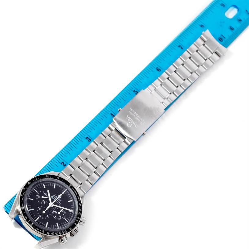 The Omega Speedmaster 3573.50.00 Men
s Stainless Steel Black Dial 3573.50.00 Men
s Stainless Steel Black Dial watch is shown from a top-down angle, featuring its face, bracelet, and clasp, measured against a blue ruler.