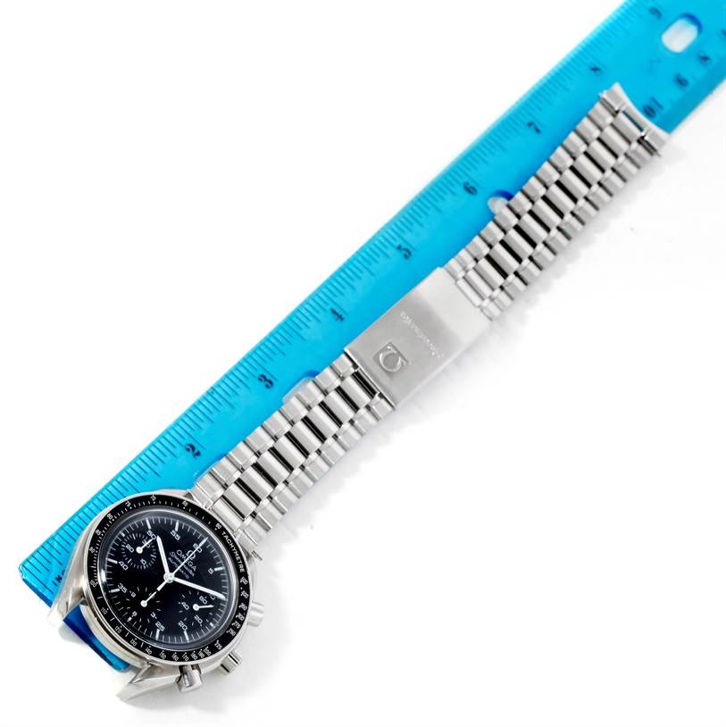 The image shows an Omega Speedmaster 3510.50.00 Men's Stainless Steel Black Dial 3510.50.00 Men's Stainless Steel Black Dial watch with its face and bracelet laid beside a blue ruler.
