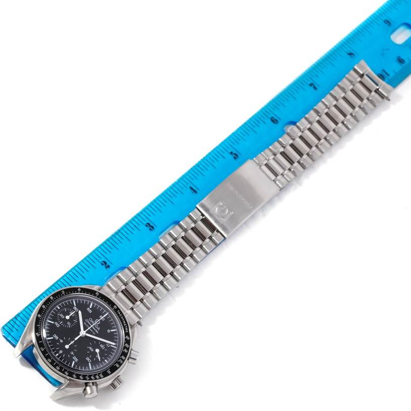 The image shows an Omega Speedmaster 3510.50.00 Men's Stainless Steel Black Dial 3510.50.00 Men's Stainless Steel Black Dial watch laid flat with its stainless steel bracelet next to a blue ruler.
