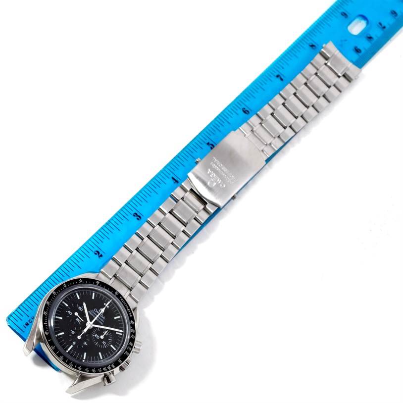 The image shows an Omega Speedmaster 3573.50.00 Men
s Stainless Steel Black Dial 3573.50.00 Men
s Stainless Steel Black Dial watch laid flat next to a blue ruler, capturing the face, bracelet, and clasp of the watch.