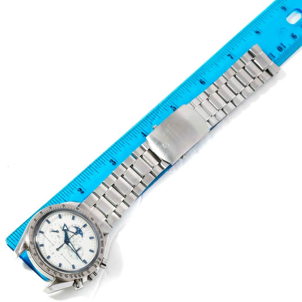 The image shows an Omega Speedmaster 3575.20.00 Men
s Stainless Steel White Dial 3575.20.00 Men
s Stainless Steel White Dial watch laid flat with a ruler for scale, displaying the watch face, strap, and clasp.