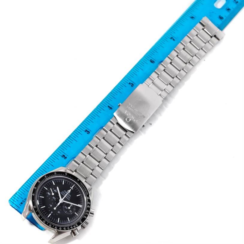 The image shows an Omega Speedmaster 3570.50.00 Men
s Stainless Steel Black Dial 3570.50.00 Men
s Stainless Steel Black Dial watch laid flat next to a blue ruler, displaying the face, bezel, and metal bracelet.