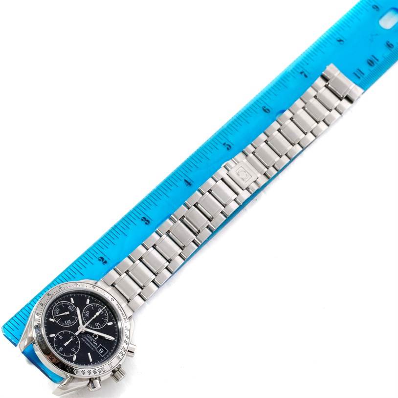 The image shows an Omega Speedmaster 3513.50.00 Men
s Stainless Steel Black Dial 3513.50.00 Men
s Stainless Steel Black Dial watch, displaying its face and stainless steel bracelet next to a blue ruler for size reference.