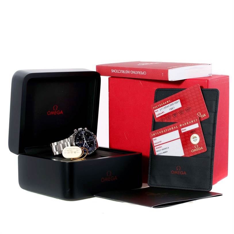 The Omega Speedmaster 311.30.42.30.01.001 Men
s Stainless Steel Black Dial 311.30.42.30.01.001 Men
s Stainless Steel Black Dial watch is shown at an angle within its open box, alongside the warranty cards, booklet, and packaging.