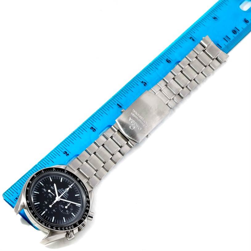 The image shows an Omega Speedmaster 3570.50.00 Men
s Stainless Steel Black Dial 3570.50.00 Men
s Stainless Steel Black Dial watch laid flat beside a ruler, highlighting its face, bracelet, and clasp.