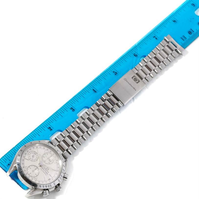 The image shows an Omega Speedmaster 3523.30.00 Men
s Stainless Steel Silver Dial 3523.30.00 Men
s Stainless Steel Silver Dial watch laid flat, with a stainless steel bracelet and clasp next to a blue ruler for scale.
