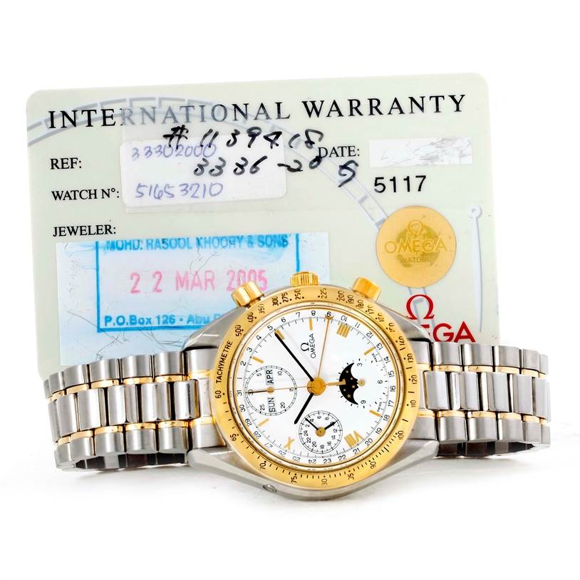 The image shows an Omega Speedmaster 3330.20.00 Men
s Stainless Steel White Dial 3330.20.00 Men
s Stainless Steel White Dial watch and its international warranty card, displayed from a top-down angle.