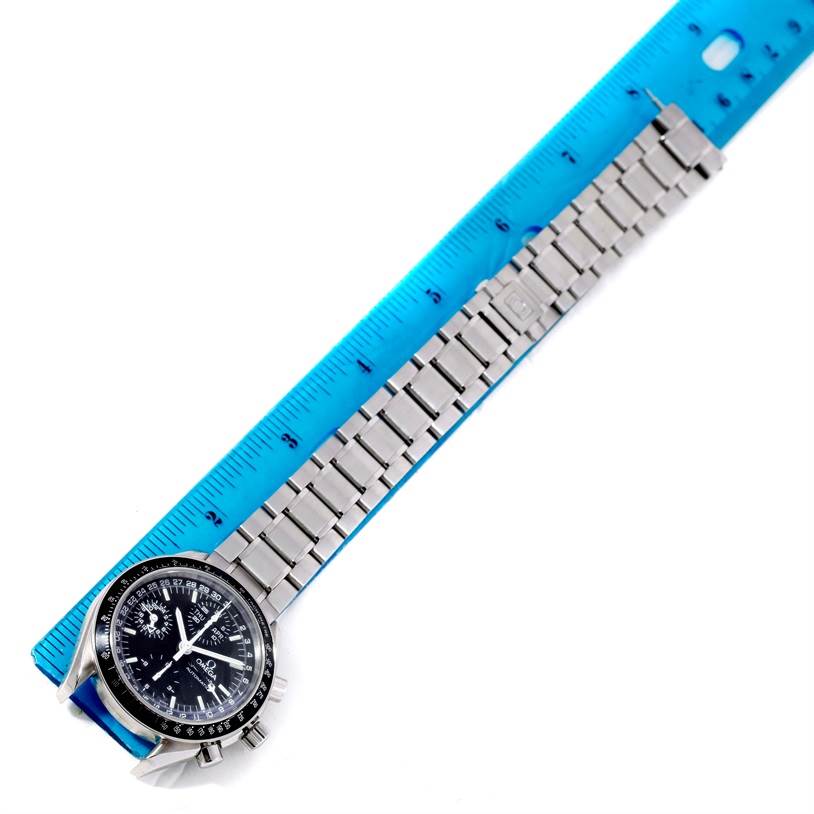 This Omega Speedmaster 3520.50.00 Men
s Stainless Steel Black Dial 3520.50.00 Men
s Stainless Steel Black Dial watch is shown from a top-down angle, displaying the full face and bracelet laid against a blue ruler.