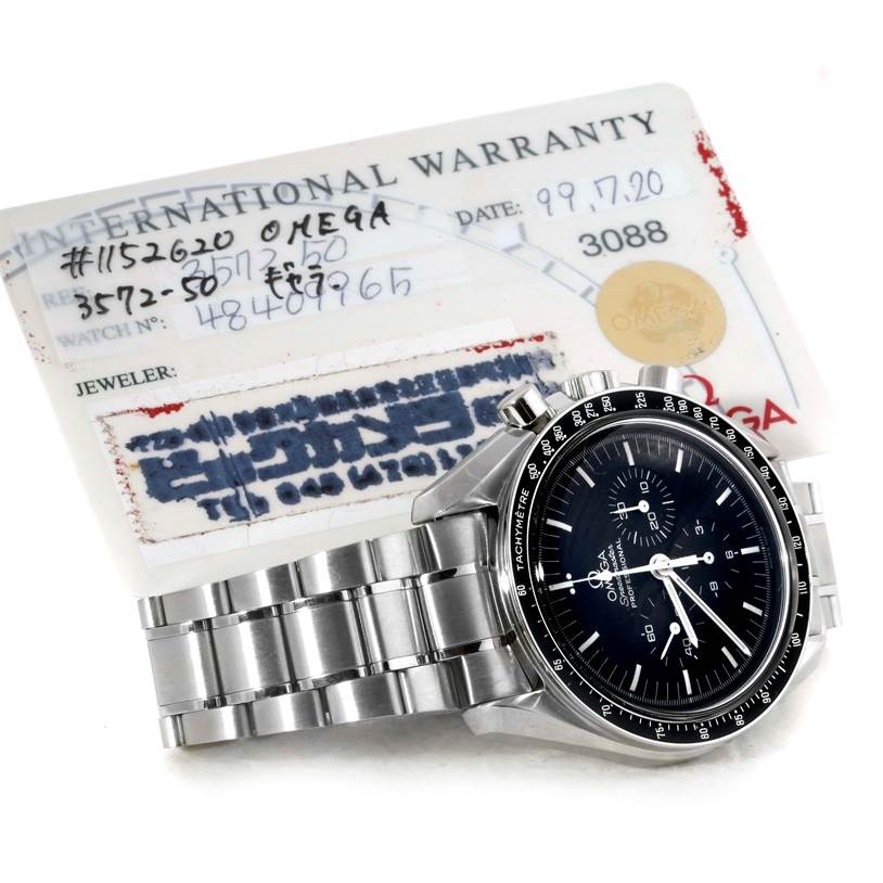The Omega Speedmaster 3572.50.00 Men
s Stainless Steel Black Dial 3572.50.00 Men
s Stainless Steel Black Dial watch is shown from a slight angle, displaying the dial, bezel, crown, pushers, and part of the bracelet, with an international warranty card in the background.