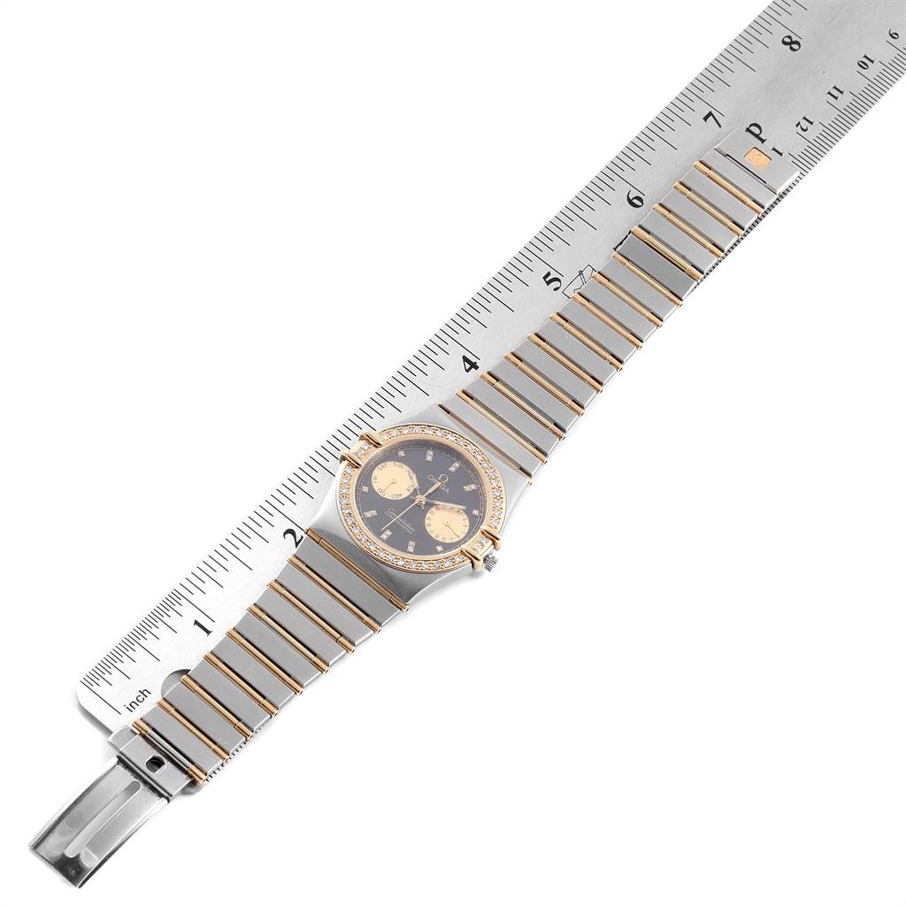 The image shows an Omega Constellation  Men's Steel and Gold (two tone) Black Dial  Men's Steel and Gold (two tone) Black Dial watch laid flat, with a ruler measuring its length.