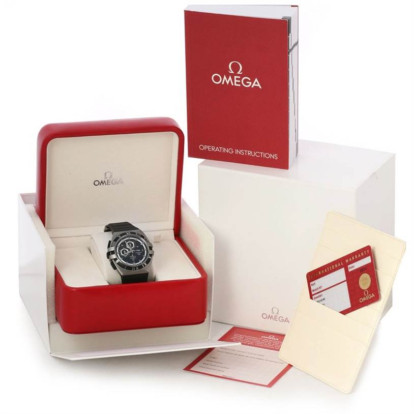 The image shows an Omega Constellation 121.92.41.50.01.001 Men's Titanium Black Dial 121.92.41.50.01.001 Men's Titanium Black Dial watch, its box, operating instructions, and warranty card from a front angle.
