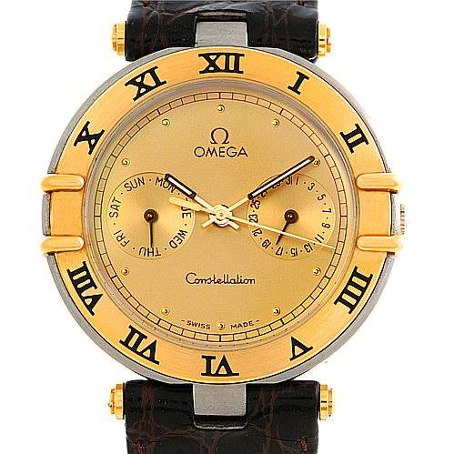The image shows a front view of an Omega Constellation Men's Steel and Gold (two tone) Champagne Dial Men's Steel and Gold (two tone) Champagne Dial watch with a gold bezel, Roman numeral markers, and a brown leather strap.