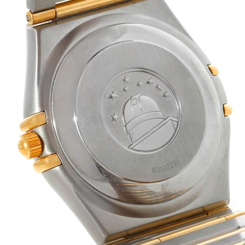 This image shows the back case and crown of an Omega Constellation 1202.30.00 Men
s Steel and Gold (two tone) Silver Dial 1202.30.00 Men
s Steel and Gold (two tone) Silver Dial watch, highlighting the embossed observatory logo.