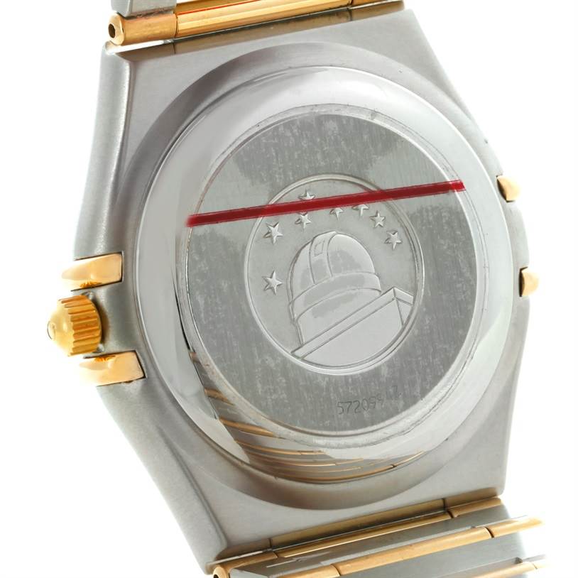 The image shows the back case and part of the bracelet of an Omega Constellation 1252.30.00 Men's Steel and Gold (two tone) Silver Dial 1252.30.00 Men's Steel and Gold (two tone) Silver Dial watch, showcasing its emblem.