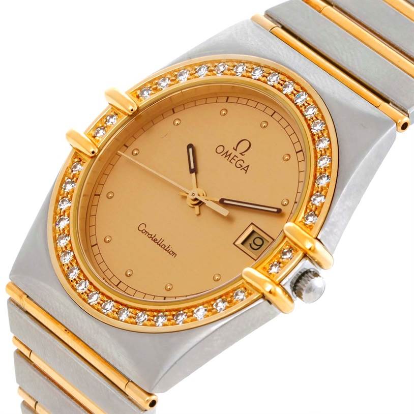 The image shows a close-up view of the Omega Constellation Men's Steel and Gold (two tone) Champagne Dial Men's Steel and Gold (two tone) Champagne Dial watch, showcasing its gold-tone dial, diamond-studded bezel, and metal bracelet.