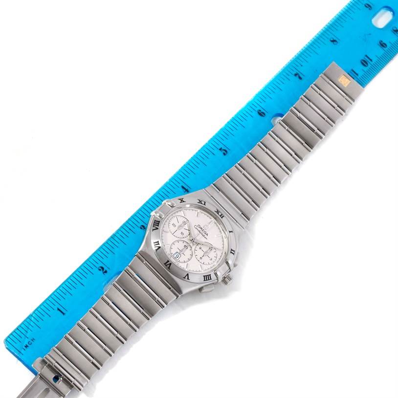 The image shows an Omega Constellation 1542.30.00 Men's Stainless Steel Silver Dial 1542.30.00 Men's Stainless Steel Silver Dial watch placed next to a ruler, displaying both the face and the full length of the bracelet.