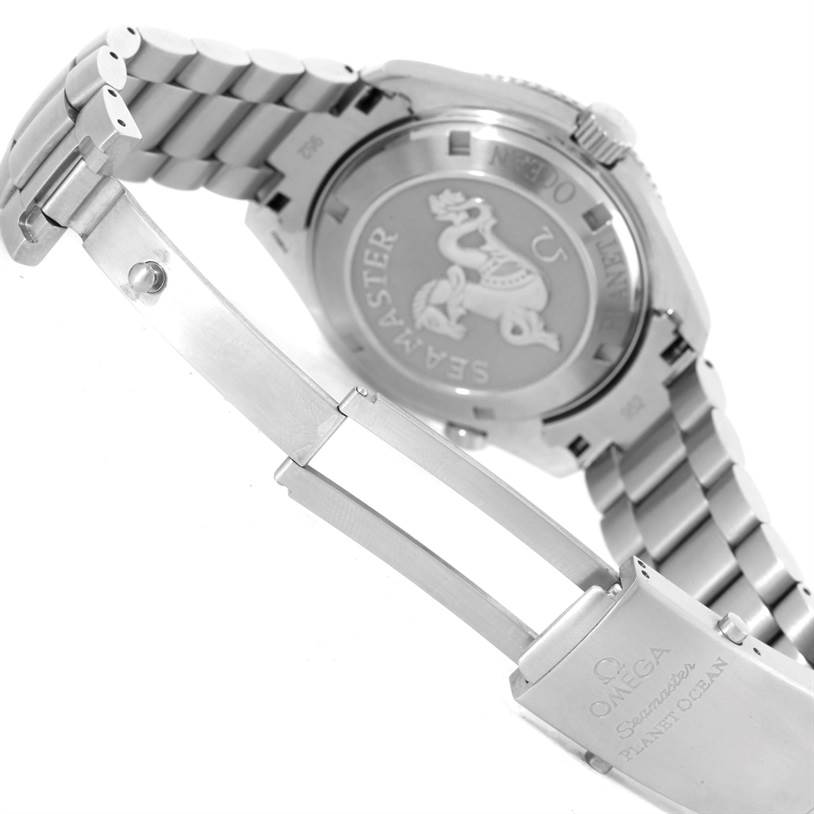 The image shows the back case and clasp of an Omega Seamaster Planet Ocean watch, highlighting its stainless steel band and engraved back.