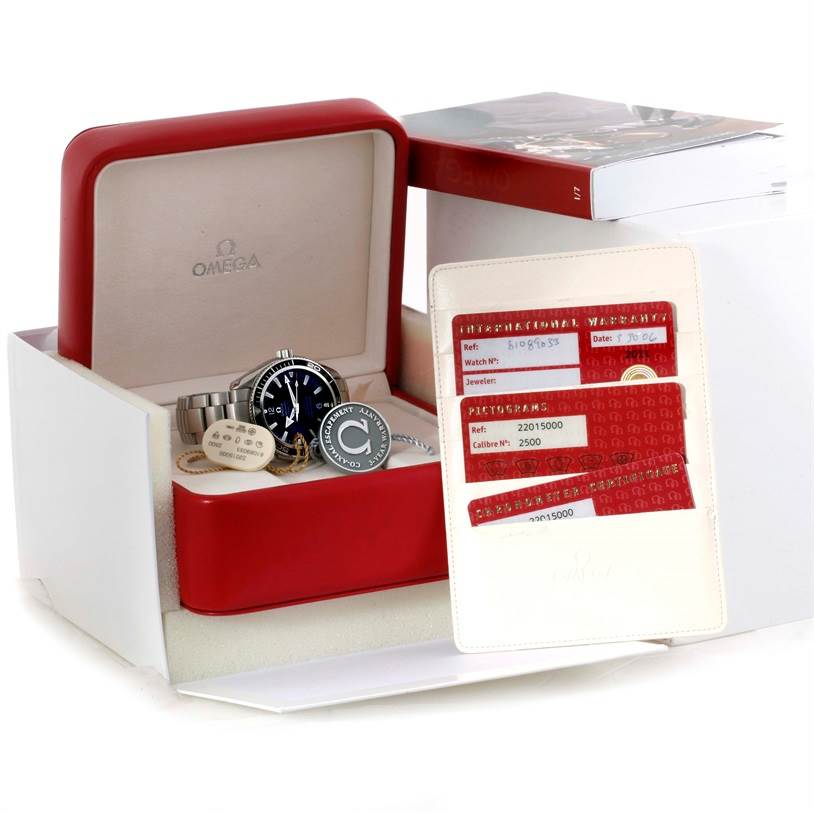 The image shows an Omega Planet Ocean 2201.50.00 Men
s Stainless Steel Black Dial 2201.50.00 Men
s Stainless Steel Black Dial watch from a front angle, with its box, Best Quality
ity cards, manual, and accessories.