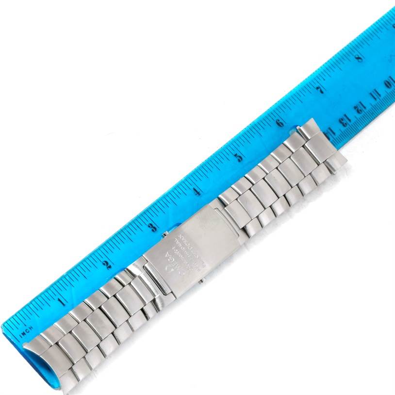 The image shows a metal bracelet of an Omega Planet Ocean 2210.51.00 Men
s Stainless Steel Black Dial 2210.51.00 Men
s Stainless Steel Black Dial watch, measured against a blue ruler.