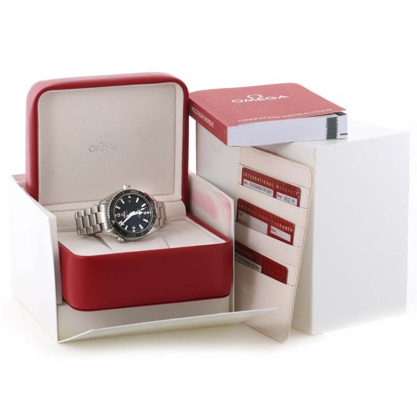 The image shows an Omega Planet Ocean 232.30.46.21.01.003 Men's Stainless Steel Black Dial 232.30.46.21.01.003 Men's Stainless Steel Black Dial watch in its box, along with warranty cards and an instruction manual.