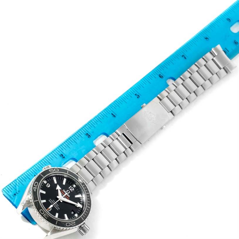 The Omega Planet Ocean 232.30.42.21.01.001 Men
s Stainless Steel Black Dial 232.30.42.21.01.001 Men
s Stainless Steel Black Dial watch is shown from an overhead angle, with a focus on the dial and band, next to a blue ruler for scale.