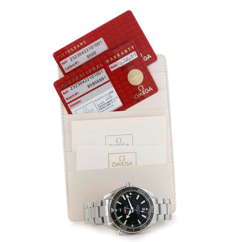 The Omega Planet Ocean 232.30.42.21.01.001 Men
s Stainless Steel Black Dial 232.30.42.21.01.001 Men
s Stainless Steel Black Dial watch is shown with its warranty cards and documentation, all laid flat.