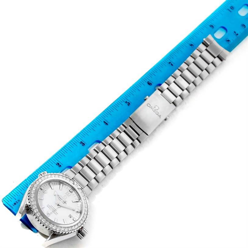 The image shows an Omega Planet Ocean 232.15.42.21.04.001 Men's Stainless Steel White Dial 232.15.42.21.04.001 Men's Stainless Steel White Dial watch laid flat with a ruler measuring its stainless steel bracelet.