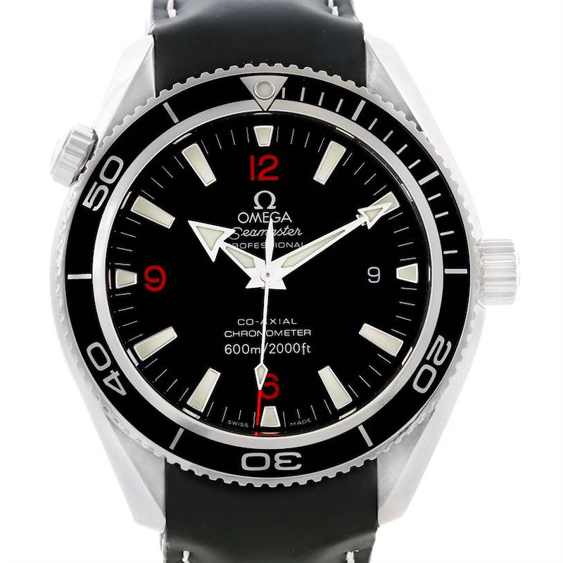 The image shows a straight-on view of the Omega Planet Ocean Seamaster watch, focusing on its black dial and black bezel with white and red accents.