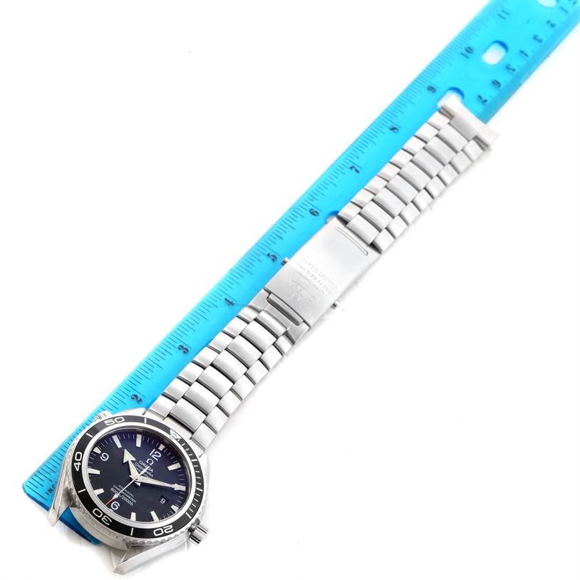 The Omega Planet Ocean 2200.50.00 Men
s Stainless Steel Black Dial 2200.50.00 Men
s Stainless Steel Black Dial watch is shown laying flat, with its face and stainless steel band fully visible, aligned against a ruler.