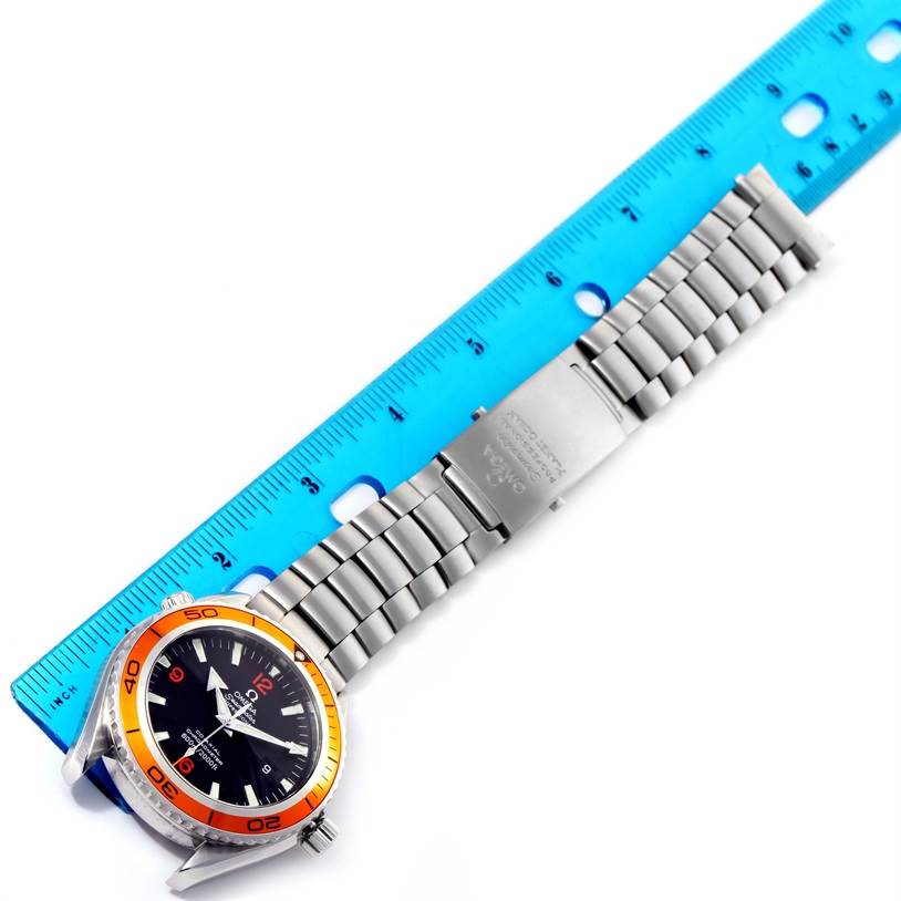 The image shows an Omega Planet Ocean 2208.50.00 Men
s Stainless Steel Black Dial 2208.50.00 Men
s Stainless Steel Black Dial watch with a metal bracelet and clasp, displayed alongside a blue ruler for measurement.