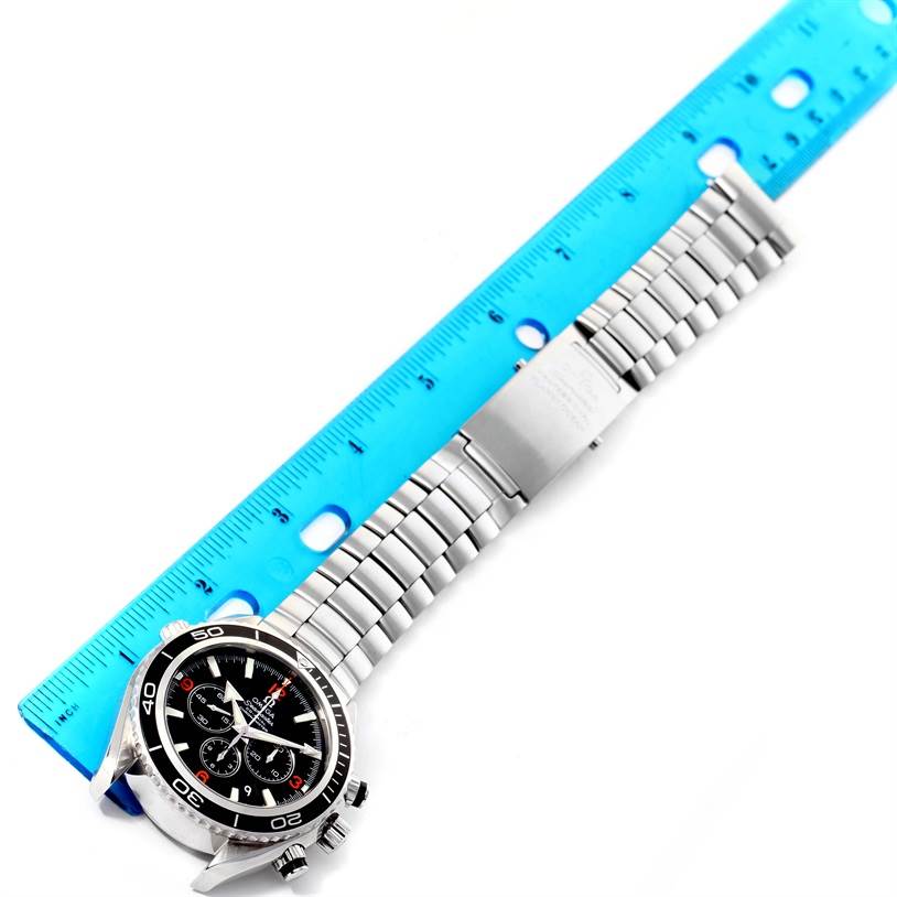 This image shows the Omega Planet Ocean 2210.51.00 Men
s Stainless Steel Black Dial 2210.51.00 Men
s Stainless Steel Black Dial watch lying flat with a blue ruler measuring its steel bracelet.