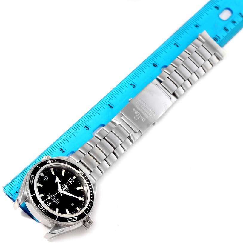 The Omega Planet Ocean 2200.50.00 Men
s Stainless Steel Black Dial 2200.50.00 Men
s Stainless Steel Black Dial watch is displayed flat with its face, bezel, and metal bracelet visible, alongside a blue ruler for measurement.