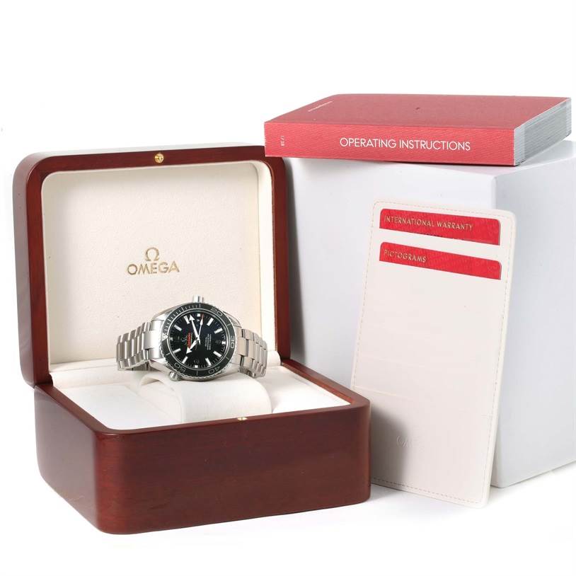 The Planet Ocean Omega watch is shown in an open box, along with operating instructions and international warranty cards.