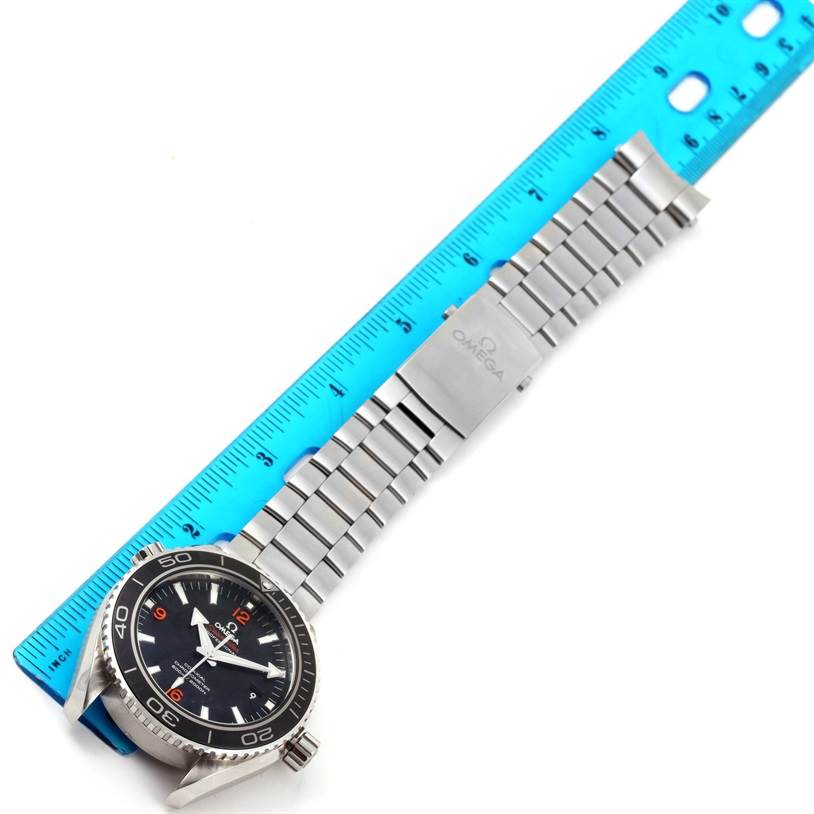 The Planet Ocean Omega watch and metal bracelet are shown alongside a blue ruler, displaying a top-down view of the timepiece.