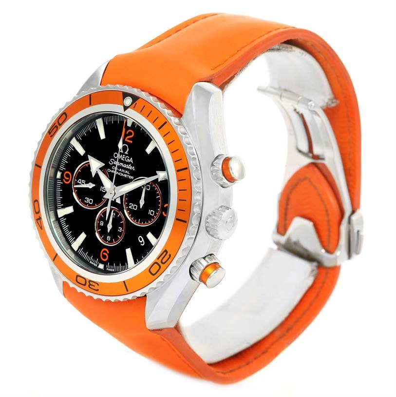 The image shows a side angle of the Omega Planet Ocean 2918.50.38 Men
s Stainless Steel Black Dial 2918.50.38 Men
s Stainless Steel Black Dial watch, highlighting its orange bezel, chronograph buttons, and orange strap.
