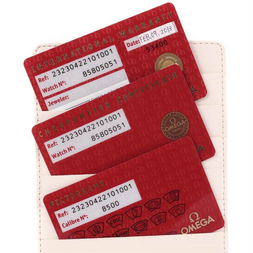 The image shows International Warranty, Chronometer Certificate, and Pictograms cards for an Omega Planet Ocean 232.30.42.21.01.003 Men
s Stainless Steel Black Dial 232.30.42.21.01.003 Men
s Stainless Steel Black Dial watch angled inside a cardholder.