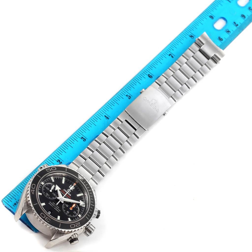 The image shows the Omega Planet Ocean 232.30.46.51.01.001 Men
s Stainless Steel Black Dial 232.30.46.51.01.001 Men
s Stainless Steel Black Dial watch, focusing on the face, bezel, and metal band next to a ruler for scale.