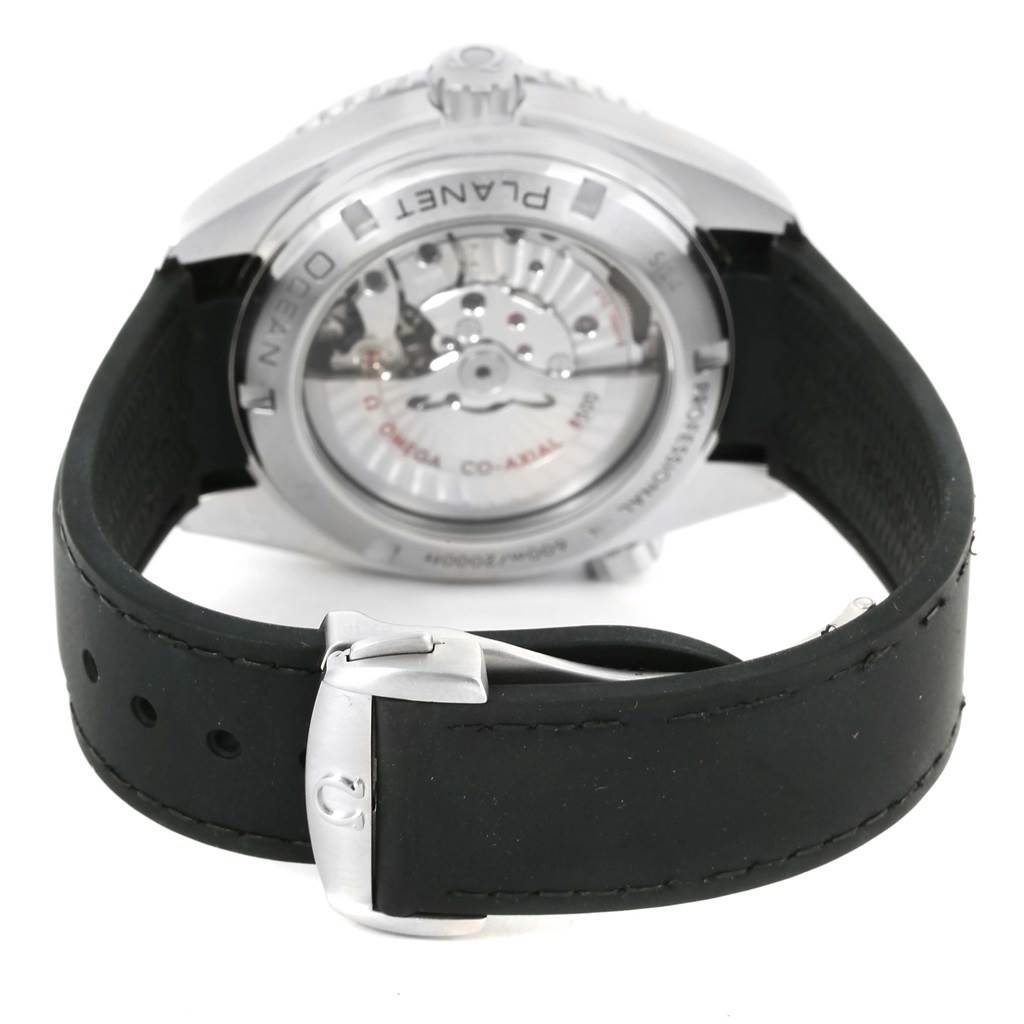 The image shows the back of the Omega Planet Ocean 232.32.46.21.01.003 Men
s Stainless Steel Black Dial 232.32.46.21.01.003 Men
s Stainless Steel Black Dial watch, highlighting the movement through the case back and part of the rubber strap and clasp.