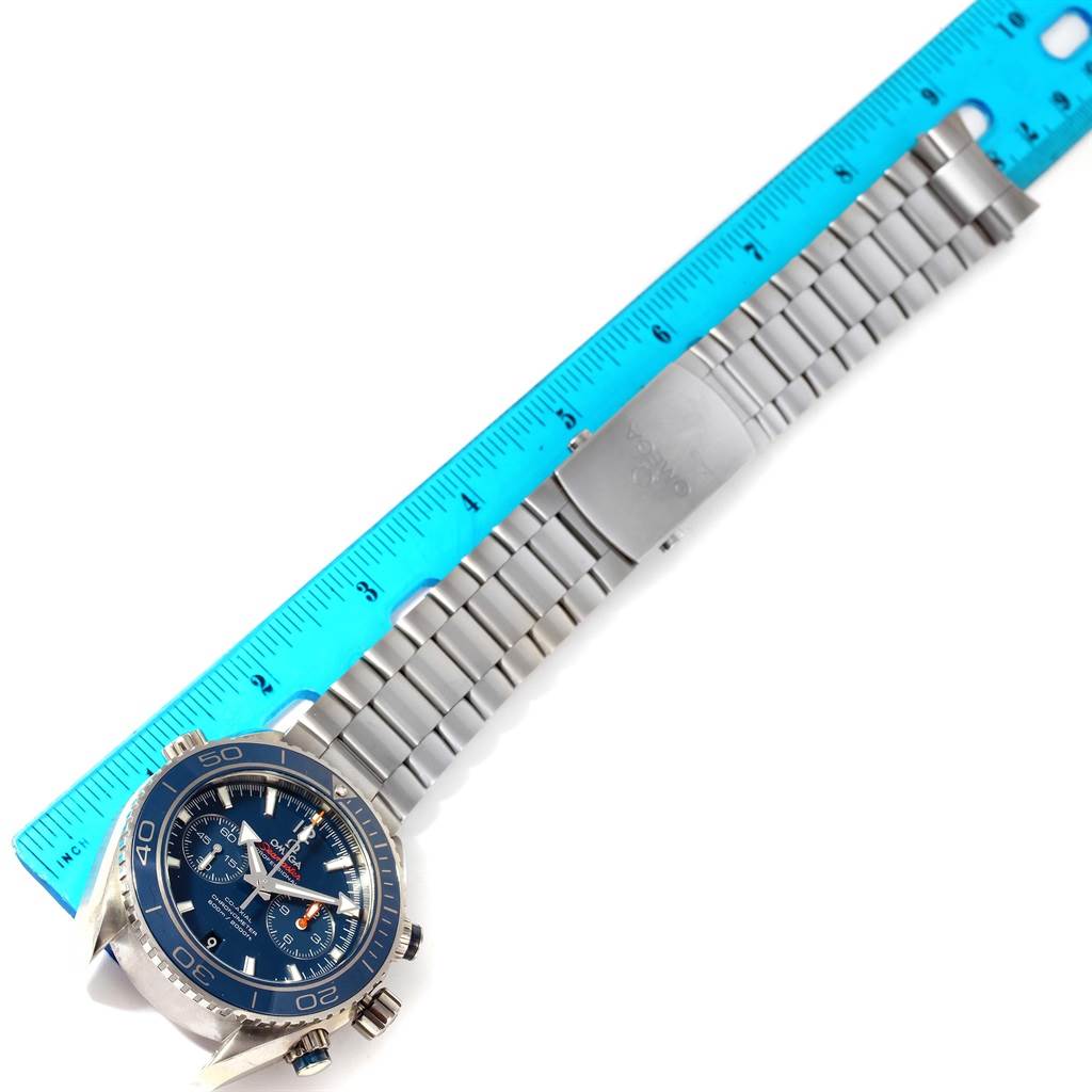 The Omega Planet Ocean 232.90.46.51.03.001 Men's Titanium Blue Dial 232.90.46.51.03.001 Men's Titanium Blue Dial watch is displayed with its face, bezel, and metal bracelet band, next to a ruler for size reference.