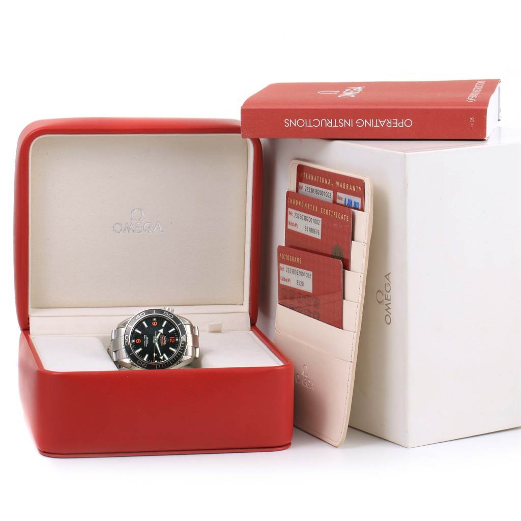 The Omega Planet Ocean 232.30.38.20.01.002 Men
s Stainless Steel Black Dial 232.30.38.20.01.002 Men
s Stainless Steel Black Dial watch is shown inside its red case, accompanied by warranty cards and an operating instructions booklet.