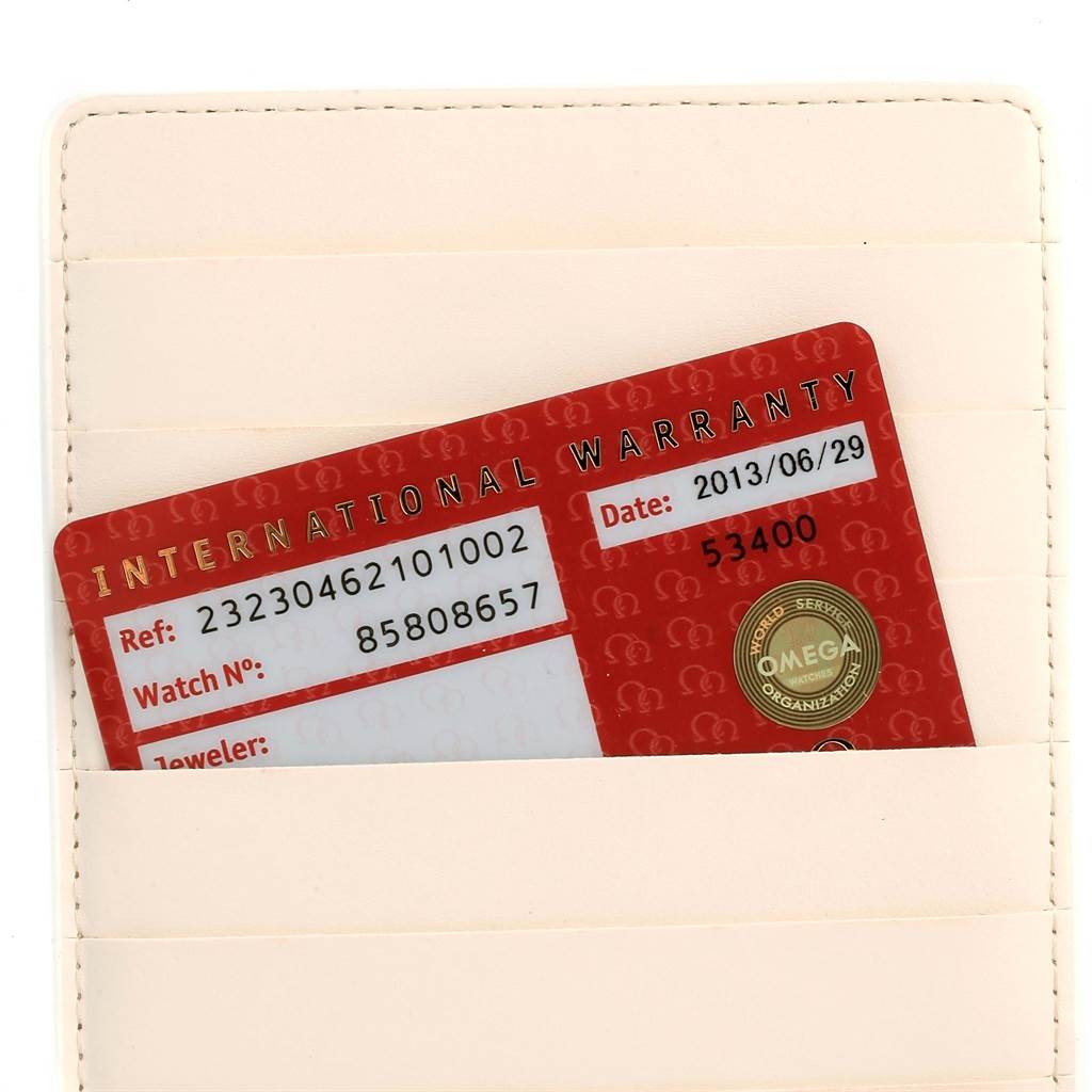 The image shows an Omega Planet Ocean 232.30.46.21.01.002 Men's Stainless Steel Black Dial 232.30.46.21.01.002 Men's Stainless Steel Black Dial model's international warranty card inside a beige cardholder.