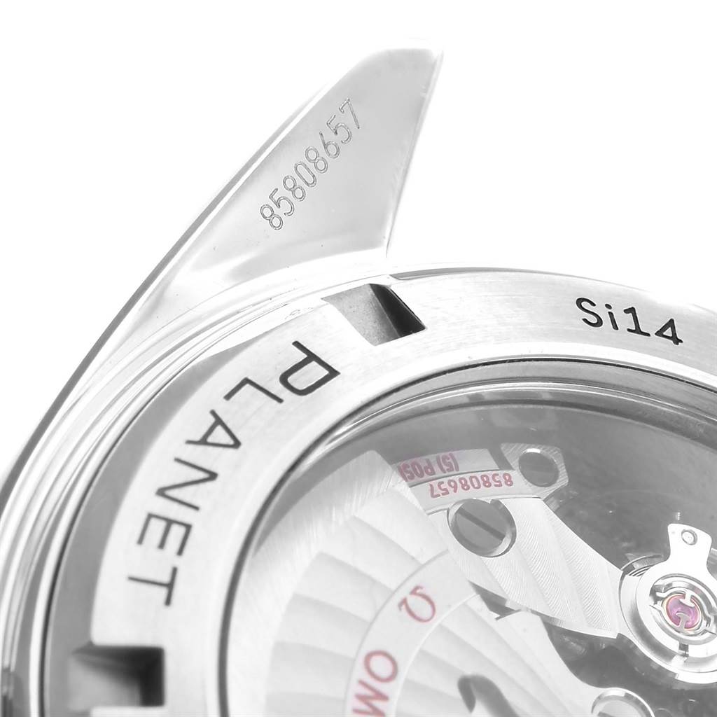 The image shows a close-up of the Omega Planet Ocean 232.30.46.21.01.002 Men's Stainless Steel Black Dial 232.30.46.21.01.002 Men's Stainless Steel Black Dial watch, highlighting part of the bezel, crystal, and movement with serial number.