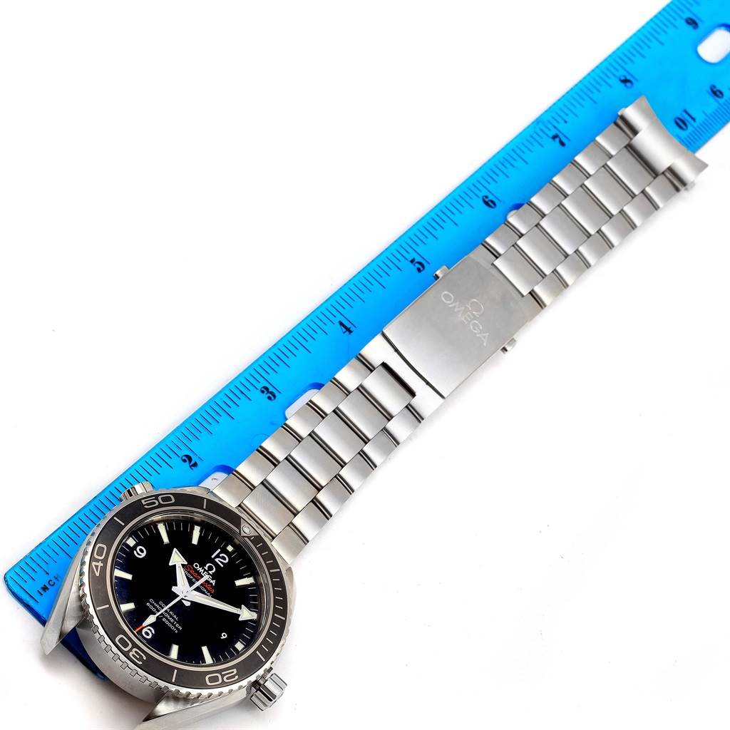 The image shows an Omega Planet Ocean 232.30.46.21.01.001 Men
s Stainless Steel Black Dial 232.30.46.21.01.001 Men
s Stainless Steel Black Dial watch laid flat with a blue ruler, displaying the face and stainless steel bracelet.