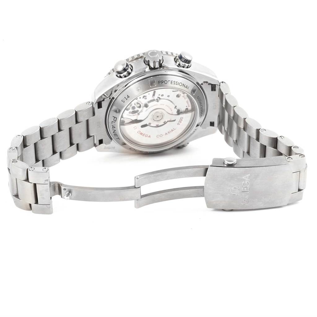 The image shows the back view of an Omega Planet Ocean 232.90.46.51.03.001 Men's Titanium Blue Dial 232.90.46.51.03.001 Men's Titanium Blue Dial watch, detailing the movement and metal bracelet with a partially open clasp.