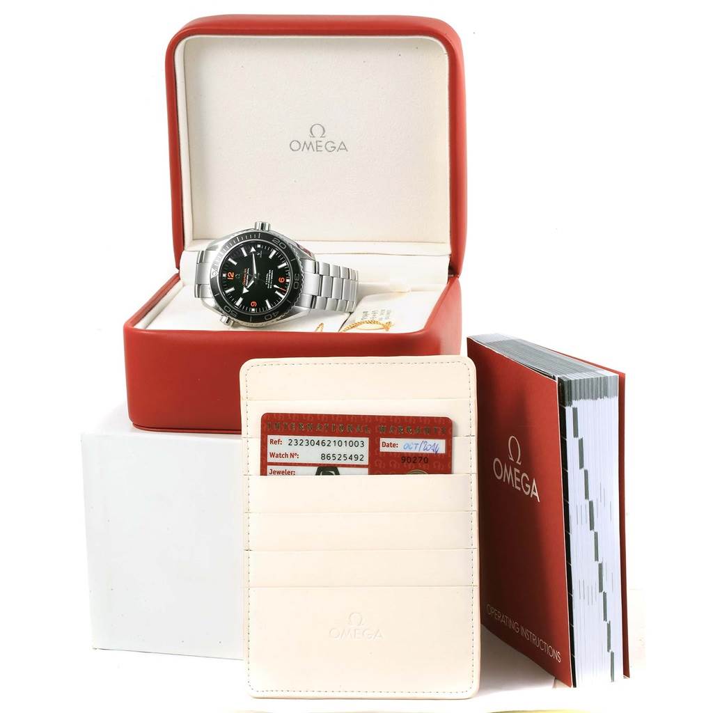 The image shows an Omega Planet Ocean 232.30.46.21.01.003 Men's Stainless Steel Black Dial 232.30.46.21.01.003 Men's Stainless Steel Black Dial watch in its open box, alongside warranty cards in a wallet and an instruction manual.